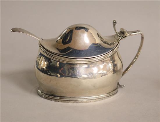 A George III silver oval mustard and a silver mustard ladle.